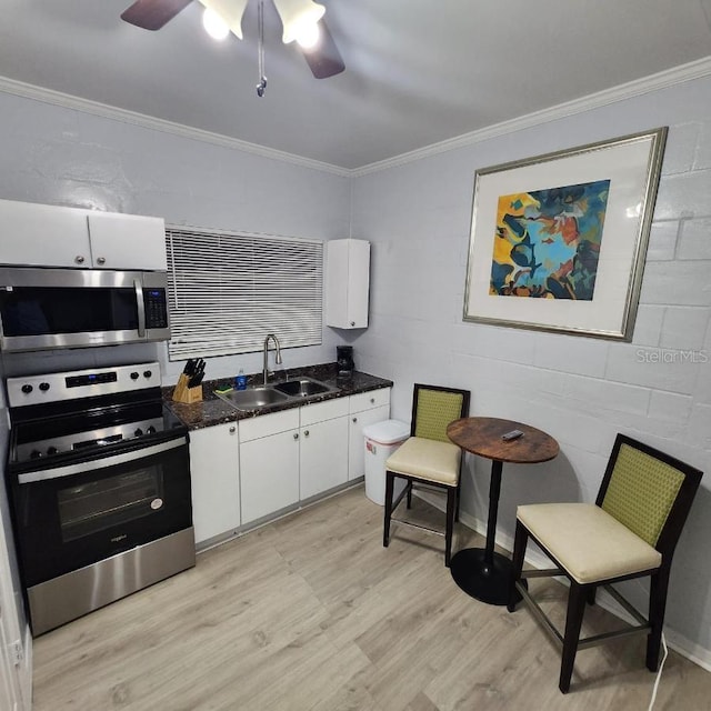 kitchen with light hardwood / wood-style floors, sink, white cabinetry, appliances with stainless steel finishes, and ceiling fan