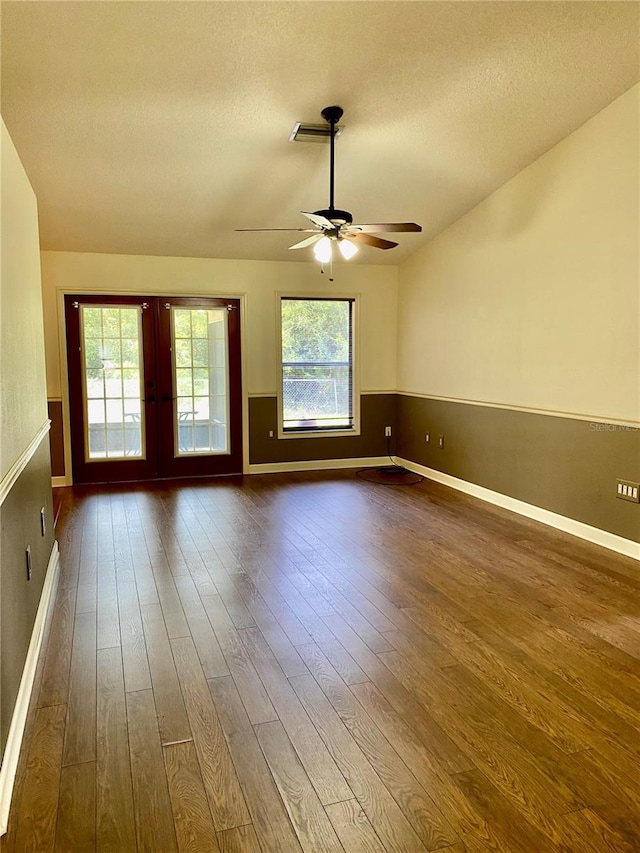 unfurnished room featuring a textured ceiling, dark hardwood / wood-style floors, ceiling fan, and french doors