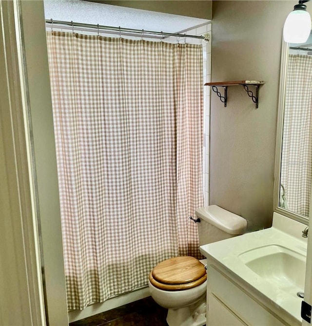 bathroom featuring curtained shower, vanity, and toilet