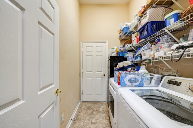 clothes washing area featuring light tile patterned flooring and independent washer and dryer