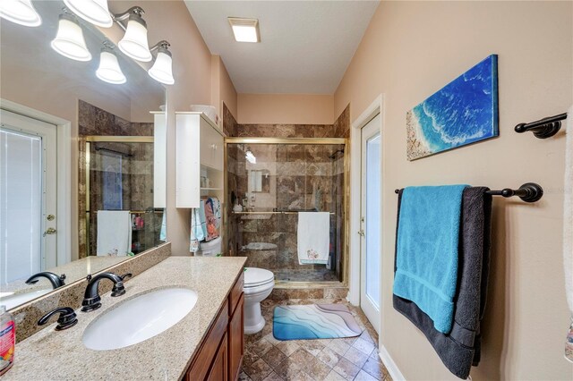 bathroom with vanity, a shower with shower door, and toilet