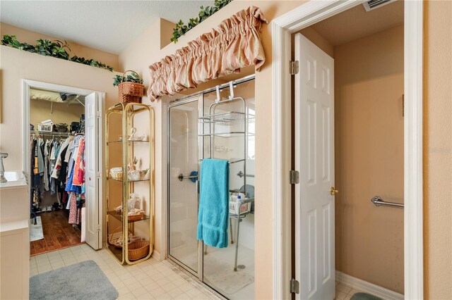 bathroom with hardwood / wood-style flooring and a shower with shower door