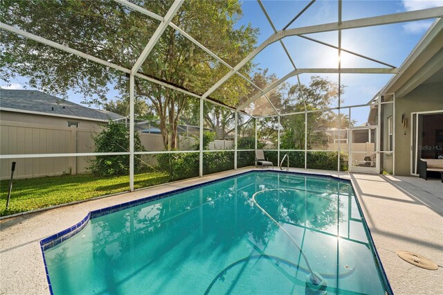 view of swimming pool with glass enclosure and a patio