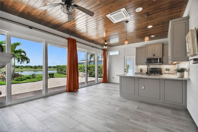 kitchen with ceiling fan, gray cabinets, appliances with stainless steel finishes, and a water view