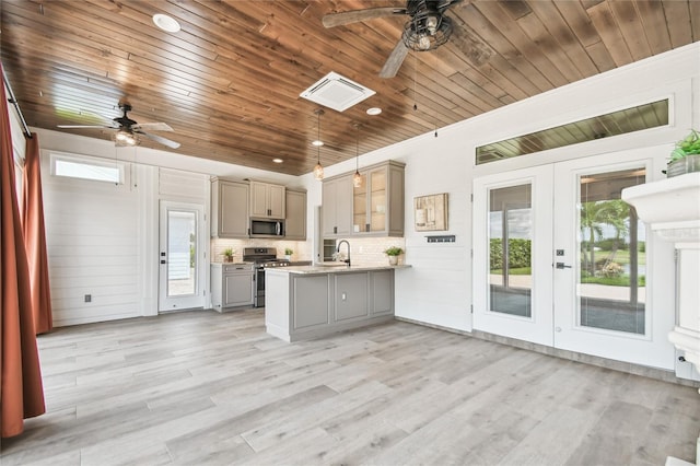 kitchen featuring light hardwood / wood-style floors, kitchen peninsula, hanging light fixtures, stainless steel appliances, and ceiling fan