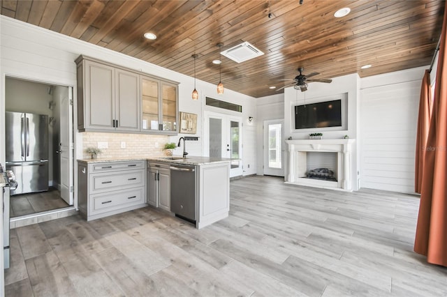 kitchen with ceiling fan, stainless steel appliances, hanging light fixtures, and gray cabinetry