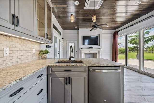 kitchen with sink, decorative light fixtures, light stone countertops, ceiling fan, and stainless steel dishwasher