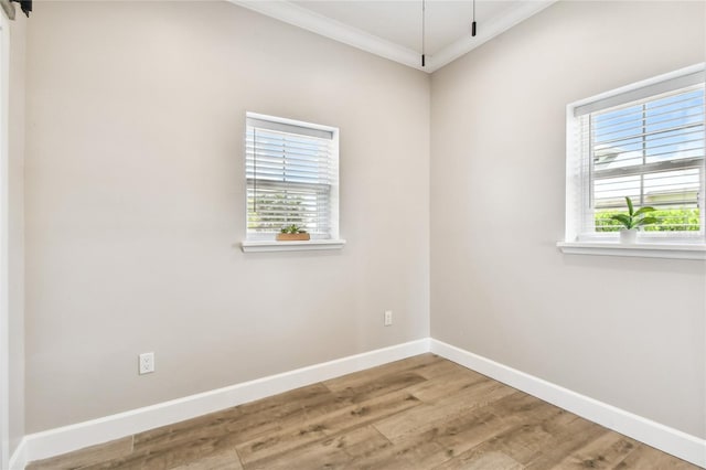 unfurnished room featuring wood-type flooring, plenty of natural light, and crown molding