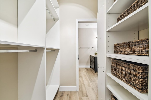 spacious closet with light hardwood / wood-style flooring