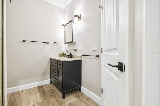 bathroom featuring ornamental molding, vanity, and hardwood / wood-style floors