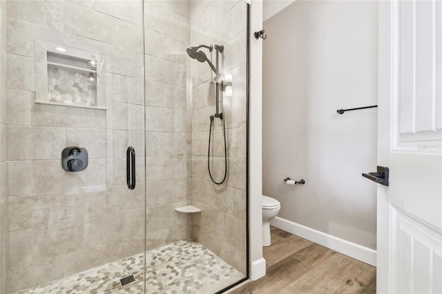 bathroom featuring hardwood / wood-style floors, toilet, and an enclosed shower