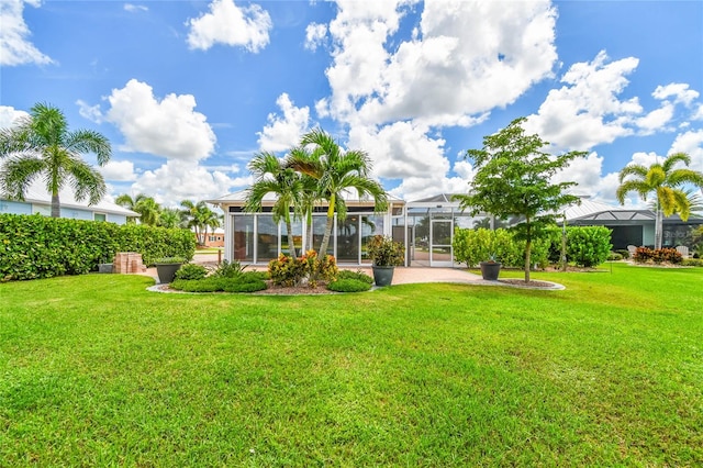 view of yard with glass enclosure and a patio