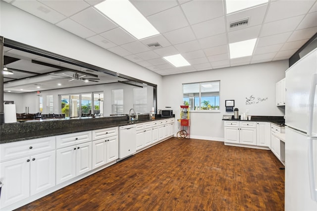 kitchen with dark hardwood / wood-style floors, white cabinetry, white appliances, dark stone countertops, and ceiling fan