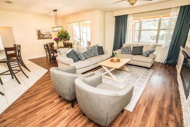 living room with wood-type flooring and ceiling fan with notable chandelier