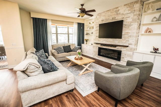 living room with built in shelves, ceiling fan, a fireplace, and dark hardwood / wood-style flooring