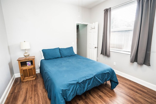 bedroom with dark hardwood / wood-style floors