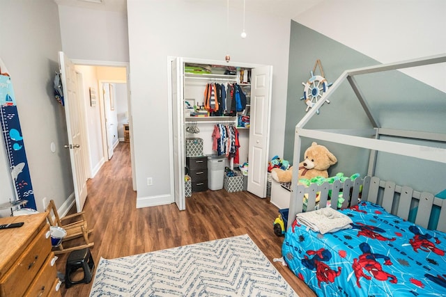 bedroom with a towering ceiling, dark hardwood / wood-style flooring, and a closet