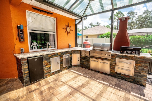 view of patio with beverage cooler, area for grilling, grilling area, and sink