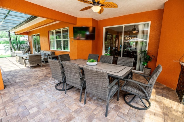 view of patio / terrace featuring ceiling fan, outdoor lounge area, and glass enclosure