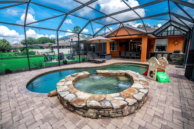 view of pool featuring glass enclosure, ceiling fan, an in ground hot tub, and a patio area