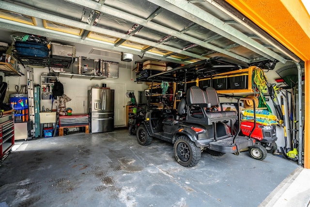 garage with stainless steel refrigerator with ice dispenser and a garage door opener