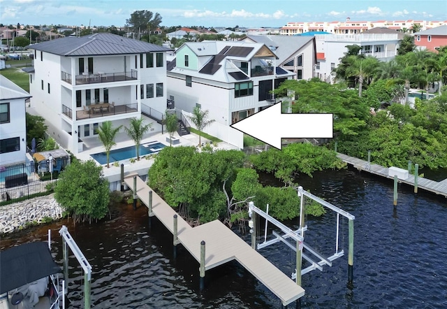 exterior space featuring a water view, a balcony, and a fenced in pool