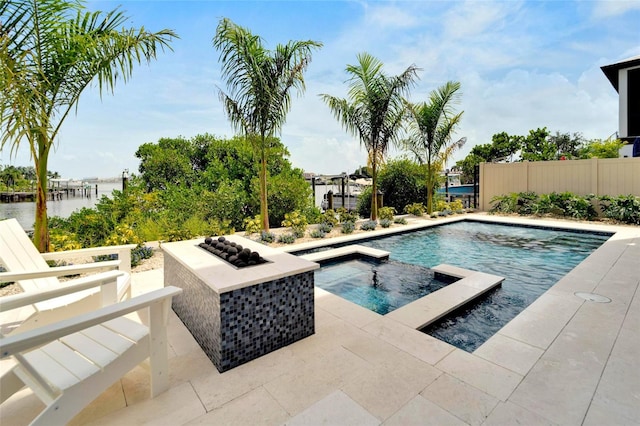 view of swimming pool featuring a patio, a water view, and an in ground hot tub