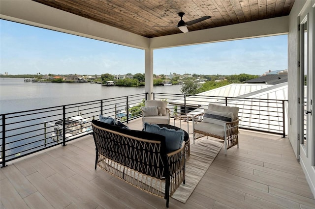 deck with outdoor lounge area, a water view, and ceiling fan