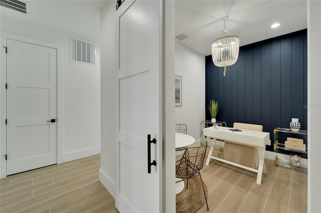 bathroom with a notable chandelier, wood walls, hardwood / wood-style floors, and a bath