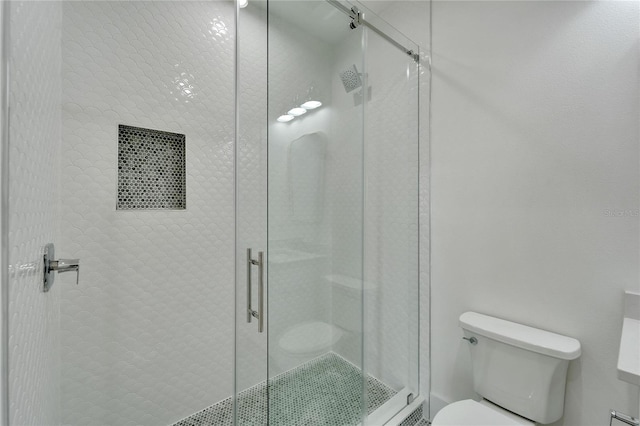 bathroom featuring toilet and an enclosed shower