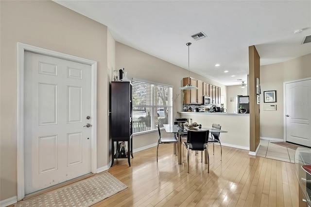 dining room with ceiling fan and light hardwood / wood-style floors