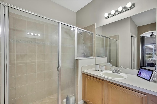 bathroom featuring an enclosed shower, vanity, and ceiling fan