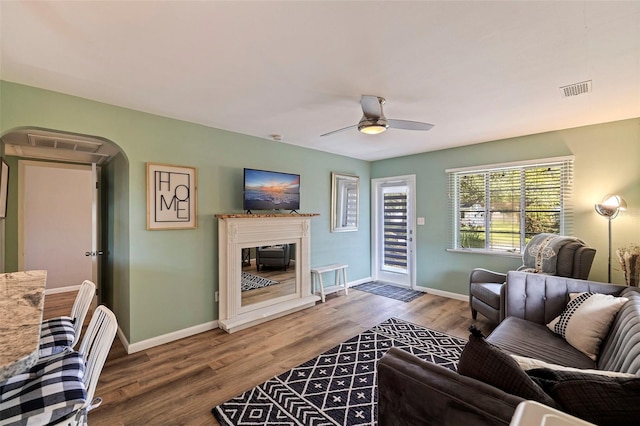 living room featuring wood-type flooring and ceiling fan