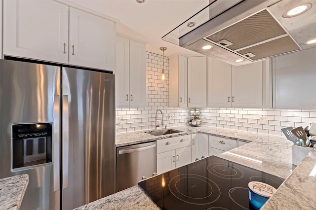 kitchen with white cabinetry, sink, stainless steel appliances, light stone countertops, and wall chimney exhaust hood