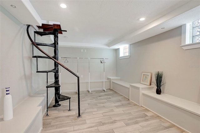 basement featuring light hardwood / wood-style flooring and a healthy amount of sunlight