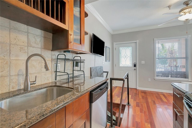 kitchen with light hardwood / wood-style floors, stone counters, appliances with stainless steel finishes, ornamental molding, and ceiling fan