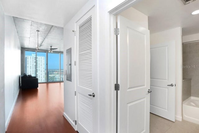 hallway with a wall of windows and light hardwood / wood-style flooring