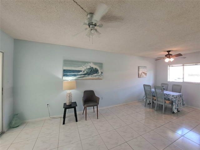 dining space featuring ceiling fan, a textured ceiling, and light tile patterned flooring