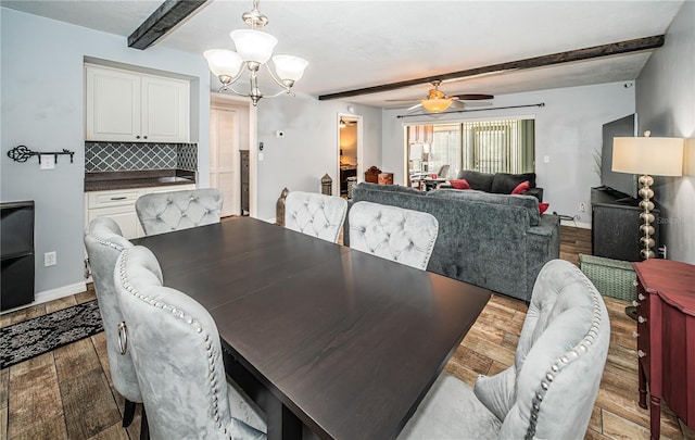 dining space featuring beamed ceiling, ceiling fan with notable chandelier, and light hardwood / wood-style floors