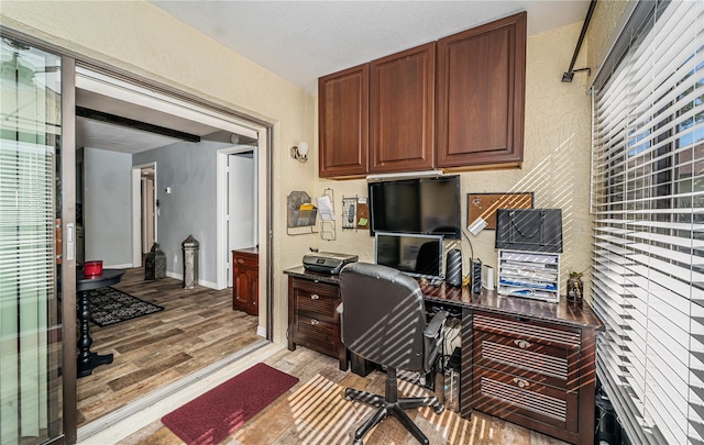 home office with light hardwood / wood-style flooring