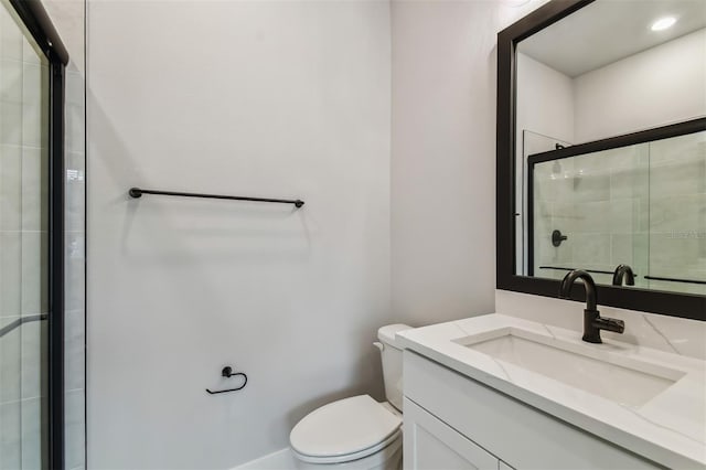 bathroom with vanity, toilet, and a shower with shower door