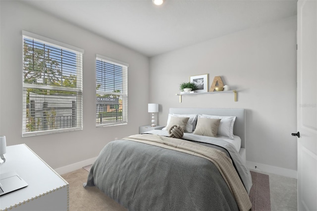 bedroom with light colored carpet and multiple windows