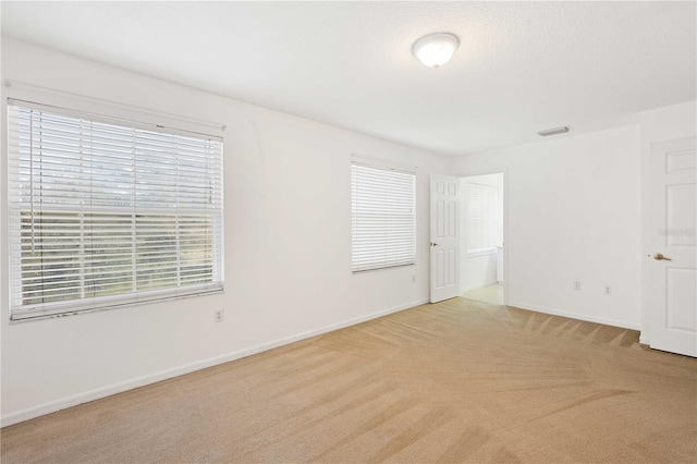 unfurnished room featuring light colored carpet