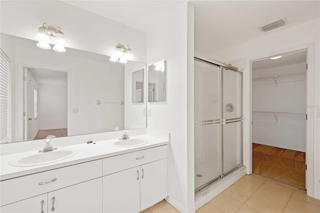 bathroom featuring tile patterned flooring, vanity, and a shower with shower door