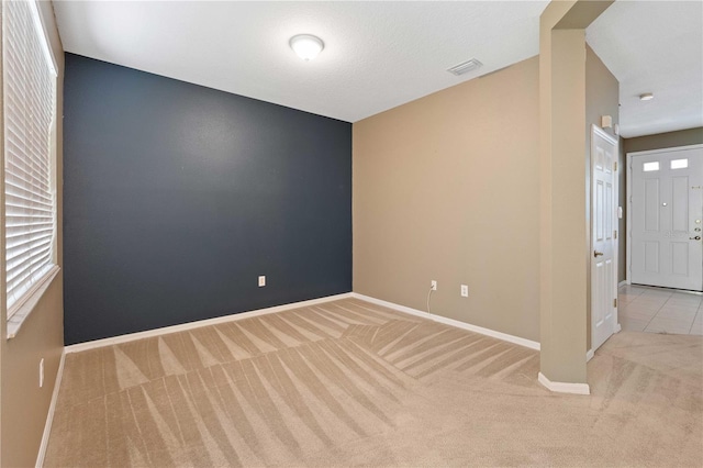 carpeted empty room featuring a textured ceiling