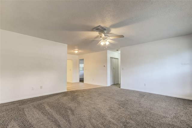 carpeted spare room with ceiling fan and a textured ceiling