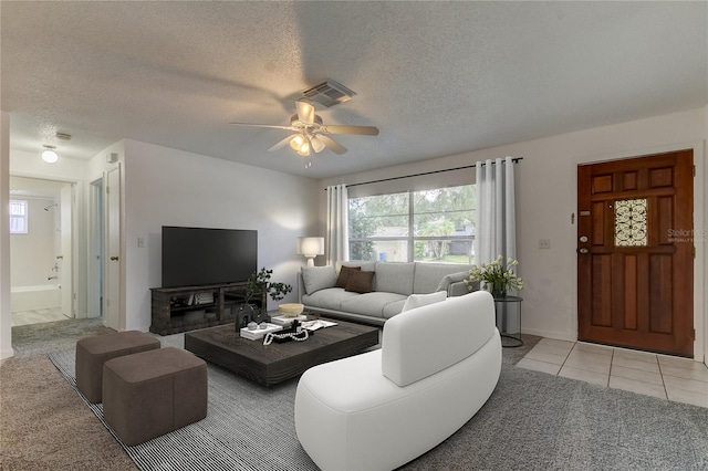 tiled living room featuring a textured ceiling and ceiling fan