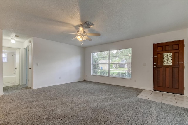 entrance foyer featuring ceiling fan, a textured ceiling, and light colored carpet