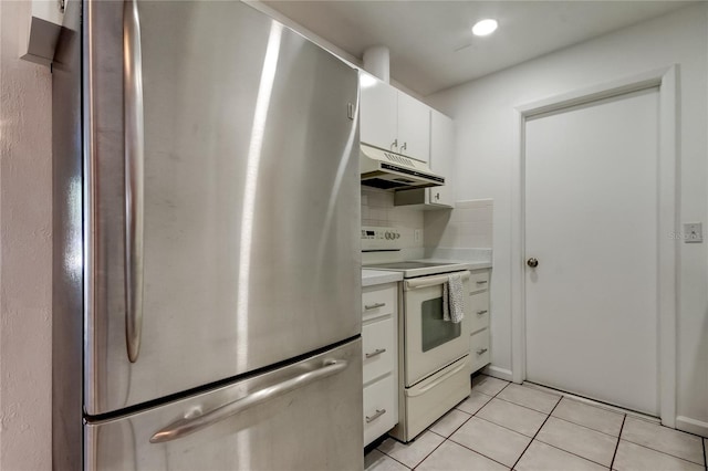 kitchen featuring backsplash, white electric stove, white cabinetry, stainless steel refrigerator, and light tile patterned floors