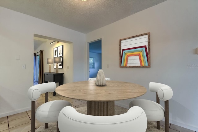 dining room featuring a textured ceiling and light tile patterned floors